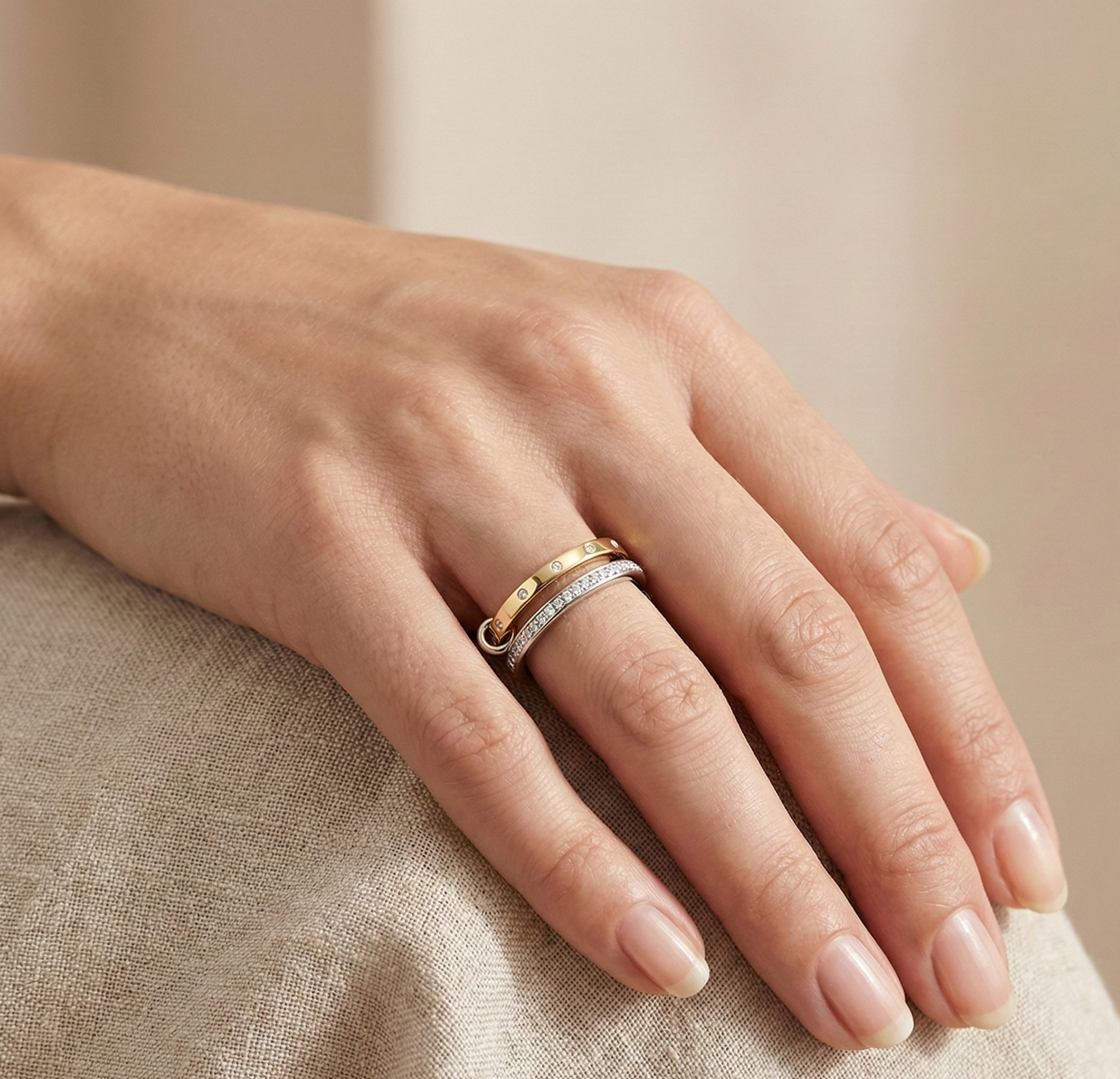 Close-up of woman wearing elegant diamond stacking ring in yellow and white gold, minimalist fine jewelry design