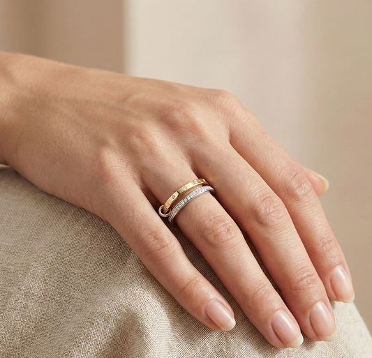 Close-up of woman wearing elegant diamond stacking ring in yellow and white gold, minimalist fine jewelry design